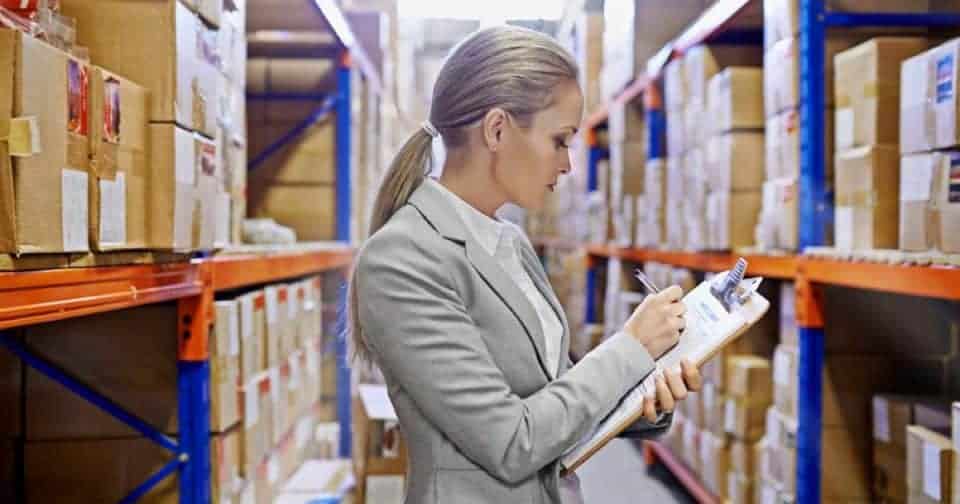 Businesswoman inspecting inventory in a warehouse.