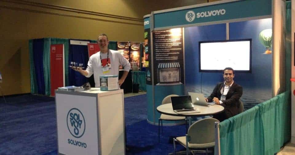 Solvoyo booth at industry event with representatives and display screens.