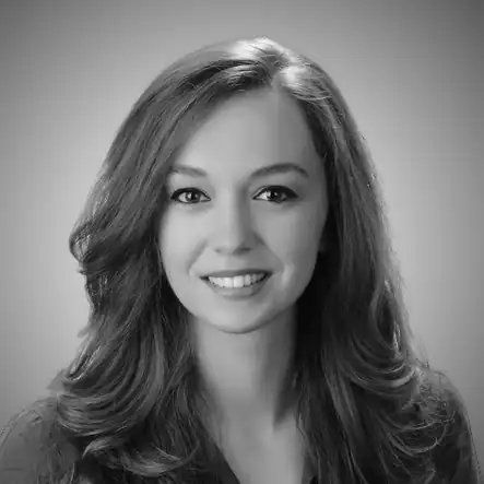 Professional woman with long wavy hair smiling for the camera.