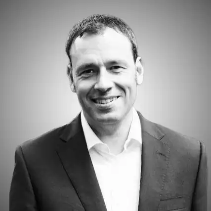 Professional man in suit smiling for a corporate portrait.